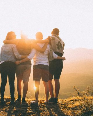 Friends arm in arm watching the sun rise