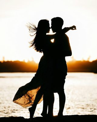 A couple embracing by the water in golden light