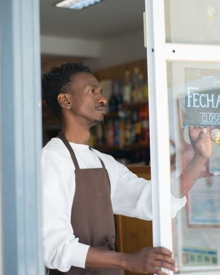 An owner opening the door of their shop