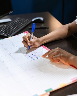 Hands writing plans in a planner
