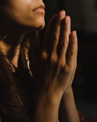 Hands pressed together in quiet thought
