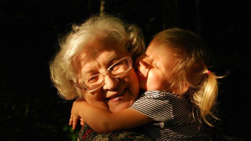 A grandmother and granddaughter sharing a warm hug